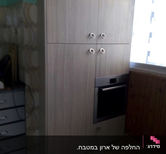ארון עץ עם ידיות עגולות ותנור מובנה